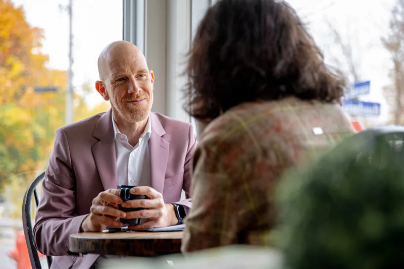 Éric en discussion avec une cliente autour d'un café