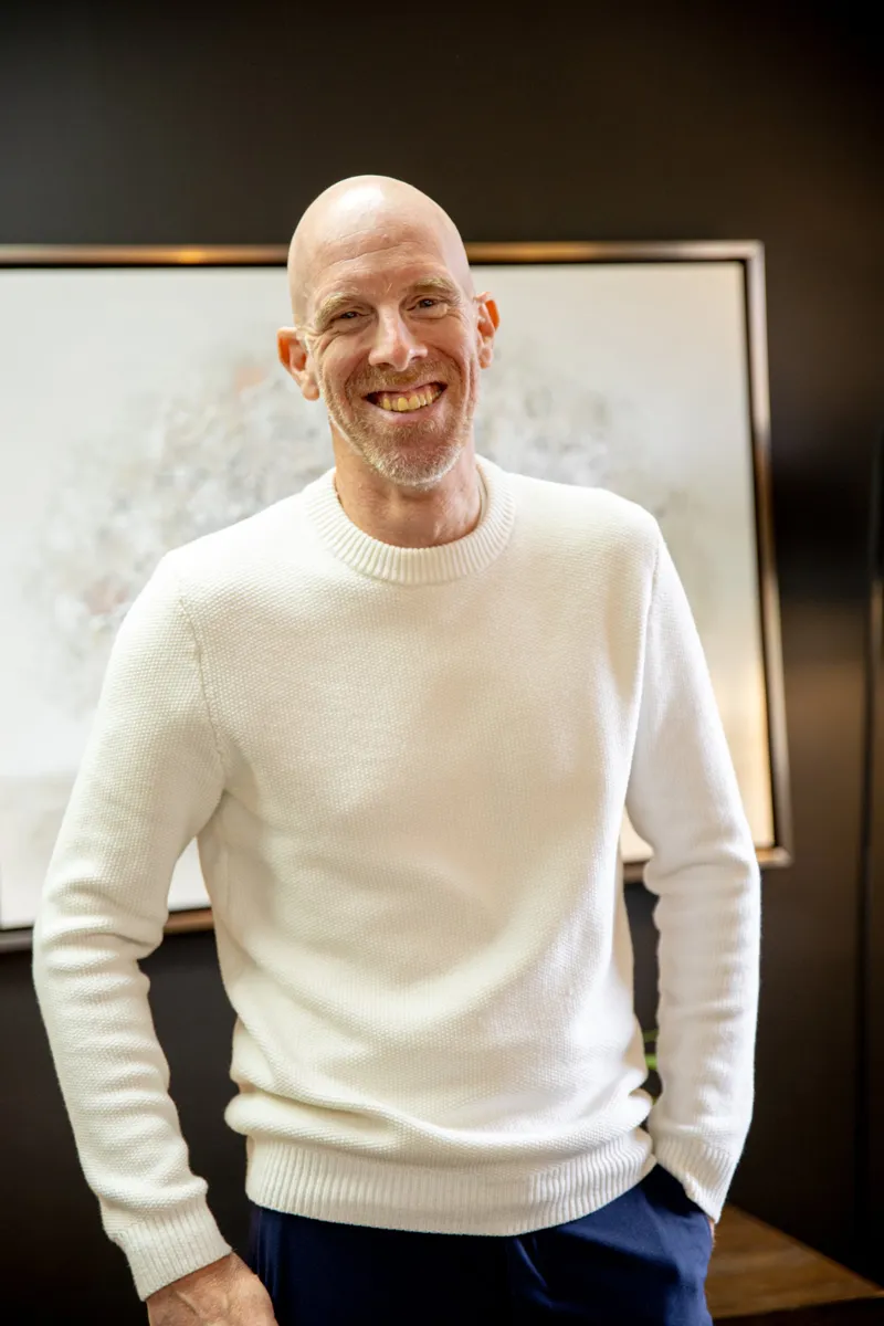 Éric Marchesseault, souriant, en chandail blanc